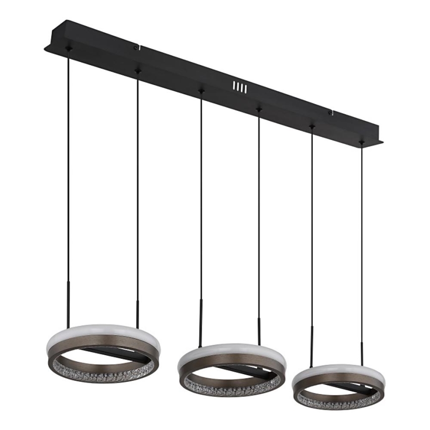 Trojité kruhové svietidlo visí z čiernej lišty. Svietidlá sú z tmavého kovu s vnútorným kruhom z kryštálikov a svetlým vnútorným okrajom. Svietidlá sú zavesené na čiernych kábloch.