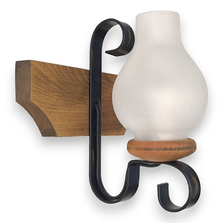 Nástenná lampa s mliečnym skleneným tienidlom v tvare hrušky, pripevnená k drevenej konzole kovaným kovom. Lampa je osadená na drevenom podstavci.