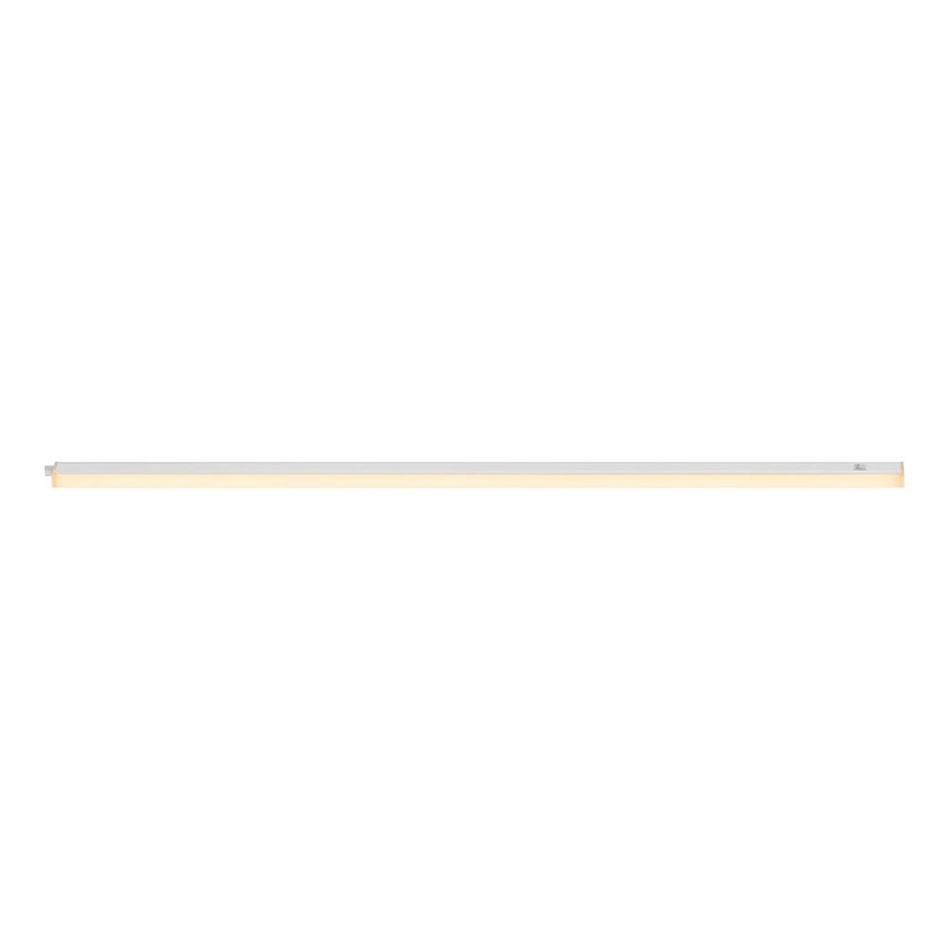 Dlhá úzka LED lampa svieti na bielom pozadí. Lampa je strieborná s teplým bielym svetlom. Je pripevnená na jednej strane.