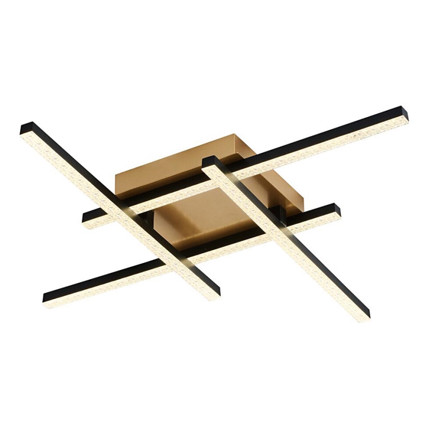 Svietidlo svieti. Zlatá štvorcová základňa je prepletená čiernymi LED pásikmi. Pásiky sú usporiadané do krížového vzoru.