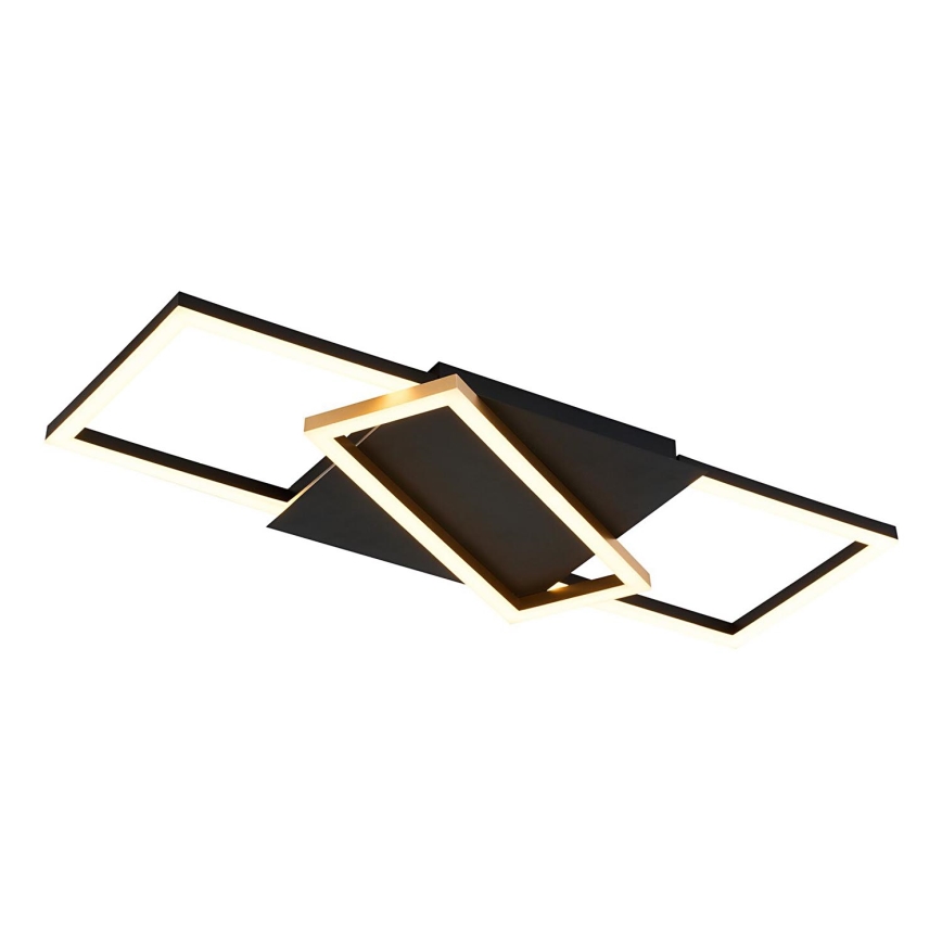 Svietidlo svieti. Je čierne s vnútorným zlatým lemovaním štvorcových prvkov. Je umiestnené na bielom pozadí.