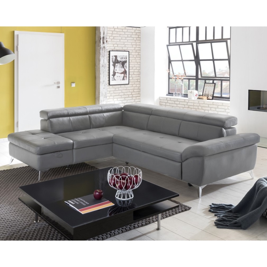 Rohová sedačka svetlošedej koženej pohovky s kovovými nohami stojí na bielom pozadí.