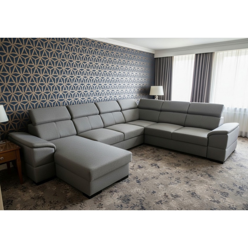 Rohová sedačka v tvare U s tmavosivým čalúnením sa nachádza na bielom pozadí. Sedačka je rozdelená do viacerých častí s operadlami a područkami.