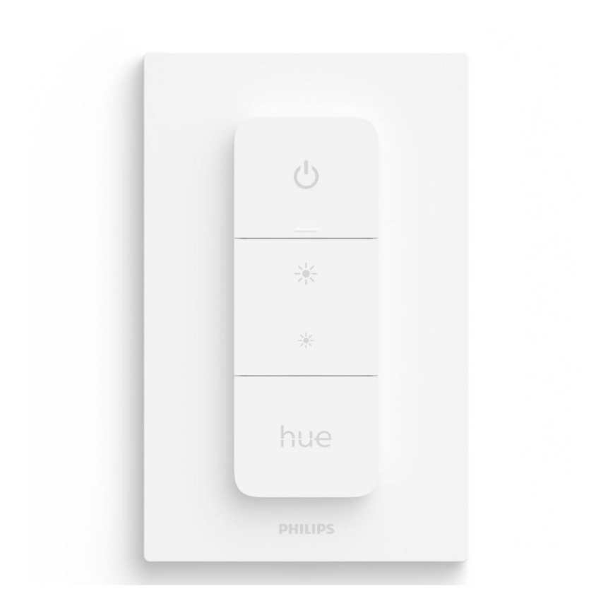 Biely stmievač Philips Hue s tlačidlami zapínania/vypínania a nastavovania jasu svetla je umiestnený na bielej stene.