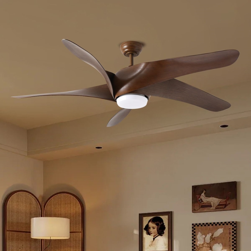 Hnedý stropný ventilátor s piatimi lopatkami sa otáča v interiéri miestnosti. Ventilátor má zabudované svetlo. Miestnosť obsahuje steny svetlohnedej farby, obrazy a stojacu lampu.